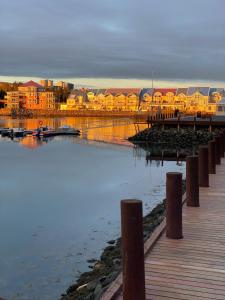 a pier next to a harbor with buildings and the water at Cozy ocean front apartment in Reykjavík