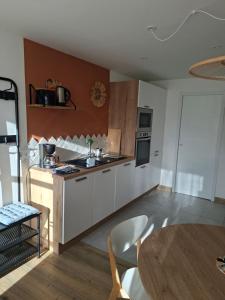 a kitchen with white cabinets and a table at Penvins in Sarzeau