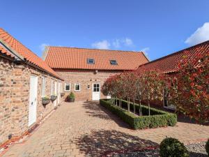 a brick building with red roofs and a brick courtyard at The Mill House in Louth