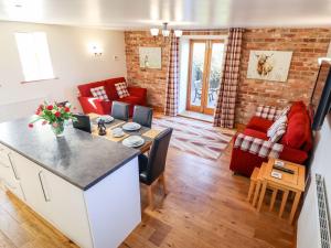 a living room with a kitchen and a living room with red furniture at The Mill House in Louth