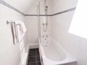 a white bathroom with a tub and a shower at The Mill House in Louth +22 photos