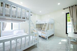 a bedroom with two bunk beds and a window at Panmora Poolvilla Sattahip in Ban Tao Than +62 photos