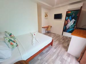 a bedroom with a white bed and a desk at CiNta Hotel in Boracay