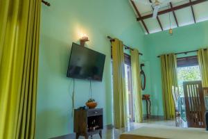 a living room with a flat screen tv on the wall at Rose Villa by Kananke Hills in Kananke