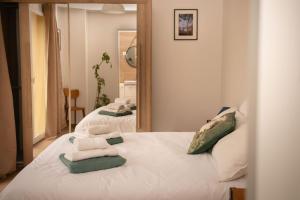 a bedroom with two beds with towels on them at Villa Pierre Blanche le calme a 5mn du centre ville in Nîmes