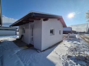 a small white building with snow on the ground at Hiška Moravska ravnica in Moravske-Toplice