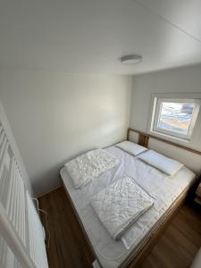 a small white room with a bed and a window at Hiška Moravska ravnica in Moravske-Toplice