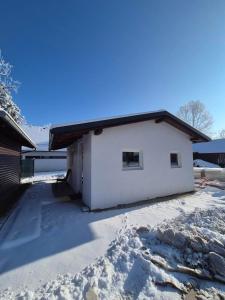 a white house with snow on the ground at Hiška Moravska ravnica in Moravske-Toplice