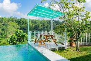 a table and a bench next to a pool at Rose Villa by Kananke Hills in Kananke