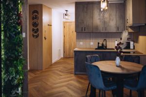 a kitchen with a table and blue chairs in a room at Apartament Panorama Boho in Mława +7 photos