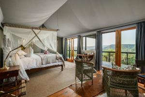 a bedroom with a canopy bed and a table and chairs at Camp Figtree by The Oyster Collection in Addo +78 photos