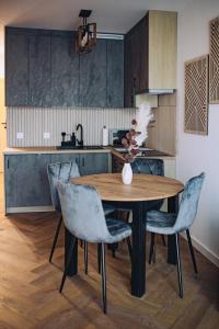 a kitchen with a wooden table and chairs at Apartament Panorama Boho in Mława