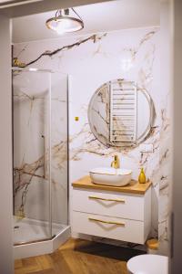 a bathroom with a sink and a shower at Apartament Panorama Boho in Mława