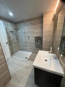 a bathroom with a shower and a sink and a tub at The Captains Wheel and Anchor in Skerries +22 photos