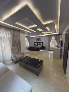a large living room with a couch and a table at Glovis Suites in Abuja +64 photos