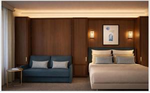 a bedroom with a bed and a blue couch at Hotel Saint Cyr Etoile in Paris +50 photos
