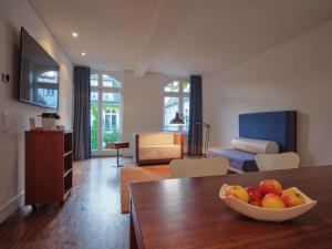a living room with a bowl of fruit on a table at Classik Hotel Antonius Köln City in Cologne +35 photos