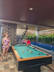 a woman and a boy playing pool in a pool table at Tasha's Place in Antipolo