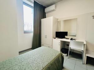 a bedroom with a bed and a desk with a computer at The Polo Hub in Mortara