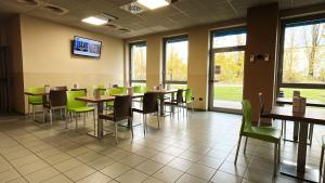 a dining room with tables and green chairs at The Polo Hub in Mortara