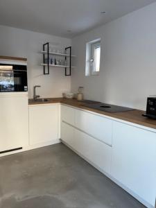 a kitchen with white cabinets and a counter top at Studio 14 in Nes +6 photos