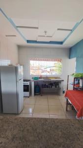 a kitchen with a refrigerator and a table in it at Hostel Casa da Cida II in Pipa