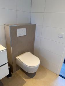 a bathroom with a white toilet in a room at Studio 14 in Nes