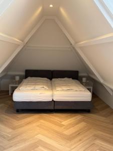 a bedroom with a bed in the attic at Studio 14 in Nes