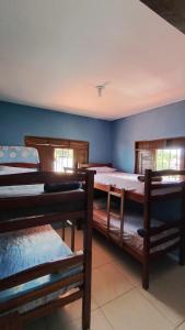 a room with three bunk beds in a room at Hostel Casa da Cida II in Pipa