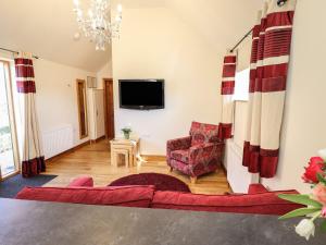 a living room with a couch and a tv at The Stables in Louth