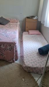 two beds in a room with pink sheets at Pantano Casa da Fafá e do Dila in Pântano Grande