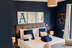 a bedroom with a large bed with blue walls at Annabelle's Den in Gatehouse of Fleet