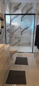 a bathroom with a shower and a sink and a toilet at Pantano Casa da Fafá e do Dila in Pântano Grande