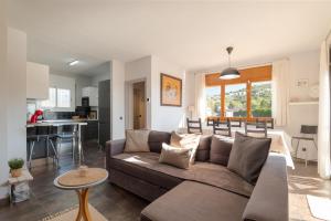 a living room with a couch and a kitchen at Mima House with Pool in Canyelles
