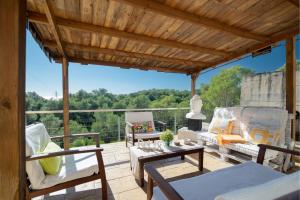 a patio with a wooden pergola with chairs and a table at Mima House with Pool in Canyelles