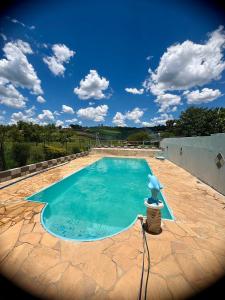 a swimming pool with a statue in the middle at Chácara do Paulinho in São Roque