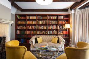 a living room with a couch and a book shelf with books at The Pear Tree in Purton