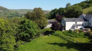a small village on a hill with houses and trees at Black Mountains Stylish Hideaway, nr Crickhowell in Llanbedr