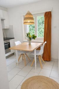 a kitchen with a wooden table and a window at Quiet Forest-Side Apartment in Flamatt