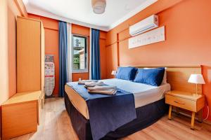 a bedroom with a bed with blue pillows and orange walls at Nehir Apart Hotel in Fethiye