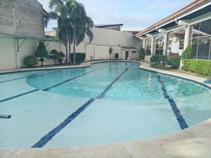 a swimming pool in a building with blue water at Casathea Hometel Cebu in Talisay