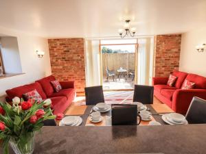 a living room with red couches and a table at The Granary in Louth