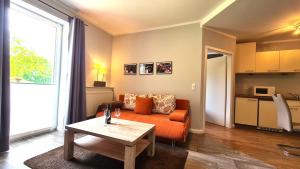a living room with an orange couch and a table at 09 Gänseweide - Hof Wiesengrund in Parchtitz