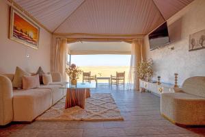 a living room with a couch and a table at Agafay Pearl Camp Marrakech in Marrakesh