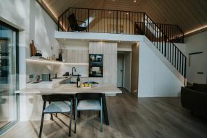 a kitchen with a sink and a counter with two chairs at Lake Forest Kabin in Bárdudvarnok