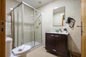 a bathroom with a shower and a toilet and a sink at Queimada Houses in Funchal +114 photos