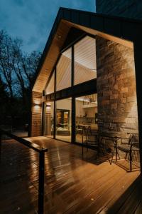 a house with a wooden deck with a large window at Lake Forest Kabin in Bárdudvarnok +6 photos