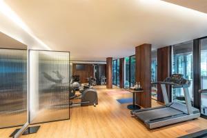 a gym with exercise equipment and glass walls at Radisson Resort Goa Baga in Baga