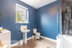 a blue bathroom with a toilet and a sink at Spacious 2 Bed Ribble Valley Apartments in Blackburn +30 photos