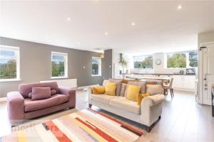 a living room with two couches and a kitchen at Spacious 2 Bed Ribble Valley Apartments in Blackburn